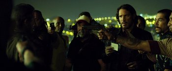Movie still from “Rambo: Last Blood” (2019), directed by Adrian Grunberg – A group of men standing next to each other holding guns; Medium shot, Over the shoulder angle