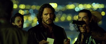 Movie still from “Rambo: Last Blood” (2019), directed by Adrian Grunberg – A man holding a piece of paper in his hand; Medium shot, Over the shoulder angle