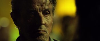 Movie still from “Rambo: Last Blood” (2019), directed by Adrian Grunberg – A man's face in a yellow light; Close Up shot, Low angle