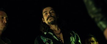 Movie still from “Rambo: Last Blood” (2019), directed by Adrian Grunberg – A man with long hair and a beard is looking at the camera; Close Up shot, Low angle