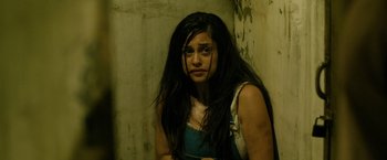 Movie still from “Rambo: Last Blood” (2019), directed by Adrian Grunberg – A woman with long black hair is looking at the camera; Medium shot, High angle