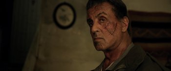Movie still from “Rambo: Last Blood” (2019), directed by Adrian Grunberg – A man with a scar on his face looking into the distance; Close Up shot, Low angle