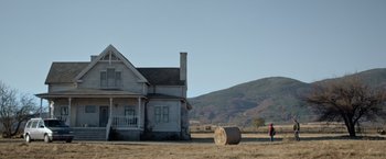 Movie still from “Rambo: Last Blood” (2019), directed by Adrian Grunberg – A person standing in front of an old farm house; Extreme Wide shot, Low angle
