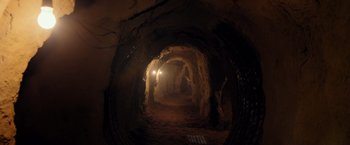 Movie still from “Rambo: Last Blood” (2019), directed by Adrian Grunberg – A dark tunnel with light coming through it; Extreme Wide shot, High angle