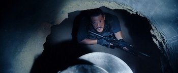 Movie still from “Rambo: Last Blood” (2019), directed by Adrian Grunberg – A man with a gun in his hand looking up at the ground; Medium shot, Overhead angle