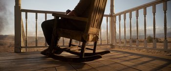 Movie still from “Rambo: Last Blood” (2019), directed by Adrian Grunberg – A man sitting in a rocking chair on a porch; Wide shot, High angle