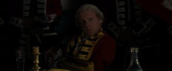 Movie still from “The Last of the Mohicans” (1992), directed by Michael Mann – A man in a red and gold jacket and a tie; Close Up shot, Over the shoulder angle