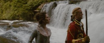 Movie still from “The Last of the Mohicans” (1992), directed by Michael Mann – Two people standing in front of a body of water near a waterfall; Medium shot, Low angle