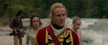 Movie still from “The Last of the Mohicans” (1992), directed by Michael Mann – A man in a red and gold uniform with two women in the background; Medium shot, Over the shoulder angle