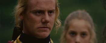 Movie still from “The Last of the Mohicans” (1992), directed by Michael Mann – A person with long blonde hair; Close Up shot, Over the shoulder angle