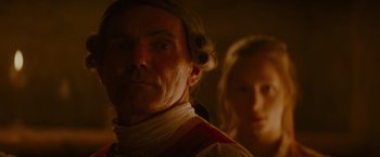 Movie still from “The Last of the Mohicans” (1992), directed by Michael Mann – A man and a woman wearing wigs in a dimly - lit room; Close Up shot, Over the shoulder angle