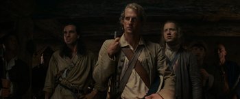 Movie still from “The Last of the Mohicans” (1992), directed by Michael Mann – A group of men sitting next to each other in a room; Medium shot, Low angle