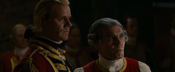 Movie still from “The Last of the Mohicans” (1992), directed by Michael Mann – Two men dressed in military uniforms and one of them is wearing a wig; Close Up shot, Over the shoulder angle