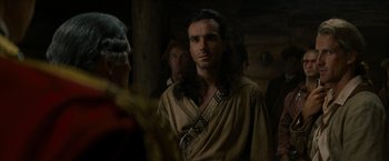 Movie still from “The Last of the Mohicans” (1992), directed by Michael Mann – A man with long black hair wearing a brown robe; Close Up shot, Over the shoulder angle