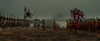 Movie still from “The Last of the Mohicans” (1992), directed by Michael Mann – A group of people standing on top of a dirt field; Extreme Wide shot, Low angle