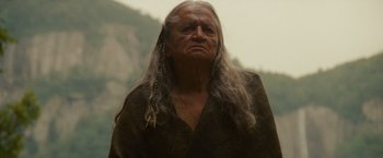 Movie still from “The Last of the Mohicans” (1992), directed by Michael Mann – An old woman with long hair and a long necklace; Close Up shot, Low angle