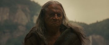 Movie still from “The Last of the Mohicans” (1992), directed by Michael Mann – An old man with long white hair is looking at the camera; Close Up shot, Low angle