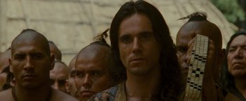 Movie still from “The Last of the Mohicans” (1992), directed by Michael Mann – A man with long black hair standing next to another man; Close Up shot, Over the shoulder angle