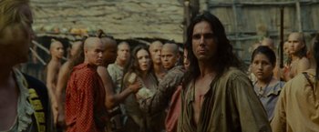 Movie still from “The Last of the Mohicans” (1992), directed by Michael Mann – A group of men standing next to each other in front of a stone building; Medium shot, Over the shoulder angle