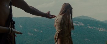Movie still from “The Last of the Mohicans” (1992), directed by Michael Mann – A woman standing on top of a hill with a hand reaching out to a man; Medium shot, High angle