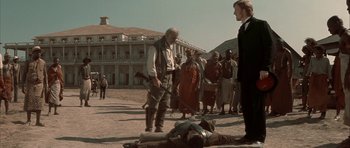 Movie still from “The League of Extraordinary Gentlemen” (2003), directed by Stephen Norrington – A group of people standing around a dead body; Wide shot, Over the shoulder angle