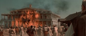 Movie still from “The League of Extraordinary Gentlemen” (2003), directed by Stephen Norrington – A group of people standing in front of a burning building; Extreme Wide shot, Low angle