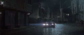 Movie still from “The League of Extraordinary Gentlemen” (2003), directed by Stephen Norrington – A car driving down a street at night; Extreme Wide shot, High angle