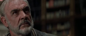 Movie still from “The League of Extraordinary Gentlemen” (2003), directed by Stephen Norrington – An old man with a beard is sitting in front of a book shelf; Close Up shot, Low angle