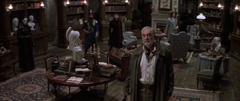 Movie still from “The League of Extraordinary Gentlemen” (2003), directed by Stephen Norrington – A man standing in front of a room full of books; Wide shot, High angle
