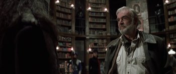 Movie still from “The League of Extraordinary Gentlemen” (2003), directed by Stephen Norrington – An older man standing in front of a bookcase in a library; Medium shot, Low angle