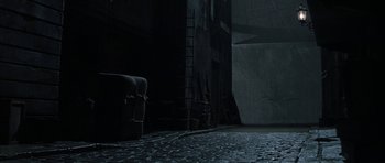 Movie still from “The League of Extraordinary Gentlemen” (2003), directed by Stephen Norrington – A dark room with a brick floor and a chair; Wide shot, High angle