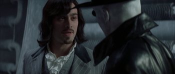 Movie still from “The League of Extraordinary Gentlemen” (2003), directed by Stephen Norrington – A man wearing a suit and a hat talking to another man; Close Up shot, Over the shoulder angle