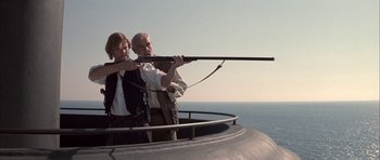 Movie still from “The League of Extraordinary Gentlemen” (2003), directed by Stephen Norrington – A man and a woman holding a rifle on top of a boat; Medium shot, Low angle