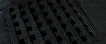 Movie still from “The League of Extraordinary Gentlemen” (2003), directed by Stephen Norrington – View of a grate in the middle of the night; Extreme Close Up shot, Overhead angle