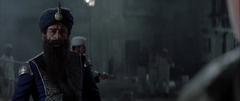 Movie still from “The League of Extraordinary Gentlemen” (2003), directed by Stephen Norrington – A man in a uniform holding a gun in front of a building; Close Up shot, Over the shoulder angle