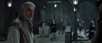 Movie still from “The League of Extraordinary Gentlemen” (2003), directed by Stephen Norrington – An older man standing next to a group of people; Close Up shot, Over the shoulder angle