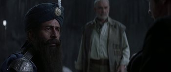 Movie still from “The League of Extraordinary Gentlemen” (2003), directed by Stephen Norrington – A man with a beard and a turban standing in front of another man; Close Up shot, Over the shoulder angle