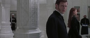 Movie still from “The League of Extraordinary Gentlemen” (2003), directed by Stephen Norrington – A man standing next to a pillar wearing a suit and tie; Close Up shot, Low angle