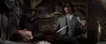 Movie still from “The League of Extraordinary Gentlemen” (2003), directed by Stephen Norrington – A man in a suit holding a knife in his hand; Medium shot, Over the shoulder angle