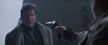 Movie still from “The League of Extraordinary Gentlemen” (2003), directed by Stephen Norrington – A man in a fur coat holding a gun pointed at him; Close Up shot, Over the shoulder angle