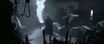 Movie still from “The League of Extraordinary Gentlemen” (2003), directed by Stephen Norrington – Two people in a dark room with a stone wall; Wide shot, High angle