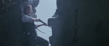 Movie still from “The League of Extraordinary Gentlemen” (2003), directed by Stephen Norrington – A person holding a sword in a cave; Wide shot, Low angle