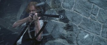 Movie still from “The League of Extraordinary Gentlemen” (2003), directed by Stephen Norrington – A woman is holding a gun and aiming it; Medium shot, High angle
