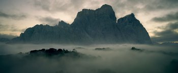 Movie still from “The Legend of Tarzan” (2016), directed by David Yates – A view of a mountain range in the fog; Extreme Wide shot, Low angle