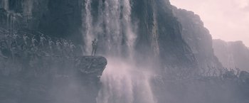 Movie still from “The Legend of Tarzan” (2016), directed by David Yates – A man standing on a cliff looking at a waterfall; Extreme Wide shot, Low angle