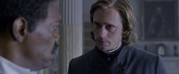 Movie still from “The Legend of Tarzan” (2016), directed by David Yates – A person with long hair and a beard; Close Up shot, Over the shoulder angle