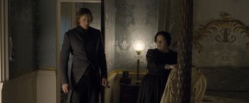 Movie still from “The Legend of Tarzan” (2016), directed by David Yates – A man and a woman standing next to each other in front of a lamp; Medium shot, Over the shoulder angle