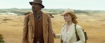 Movie still from “The Legend of Tarzan” (2016), directed by David Yates – A man and a woman standing in a field holding hands; Close Up shot, Low angle