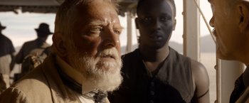 Movie still from “The Legend of Tarzan” (2016), directed by David Yates – A man with a white beard standing next to a man with a black shirt; Close Up shot, Over the shoulder angle