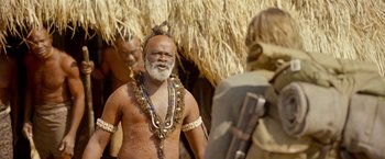 Movie still from “The Legend of Tarzan” (2016), directed by David Yates – An old man with a long beard is standing in front of another man; Medium shot, Over the shoulder angle